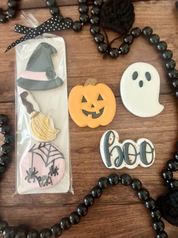 A wooden table with halloween cookies and beads.